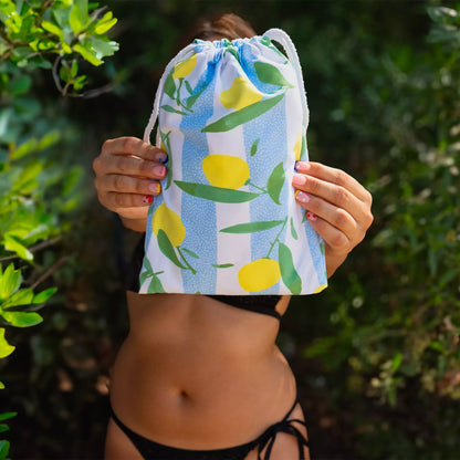 A girl holding a Quick Dry, Sand Free, Light Weight, Compact and Ecofriendly Microfiber Beach Towel inside a pouch from La Toalla