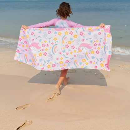 A girl running on the sand with a Quick Dry, Sand Free, Light Weight, Compact and Ecofriendly Microfiber Beach Towel from La Toalla with kids design
