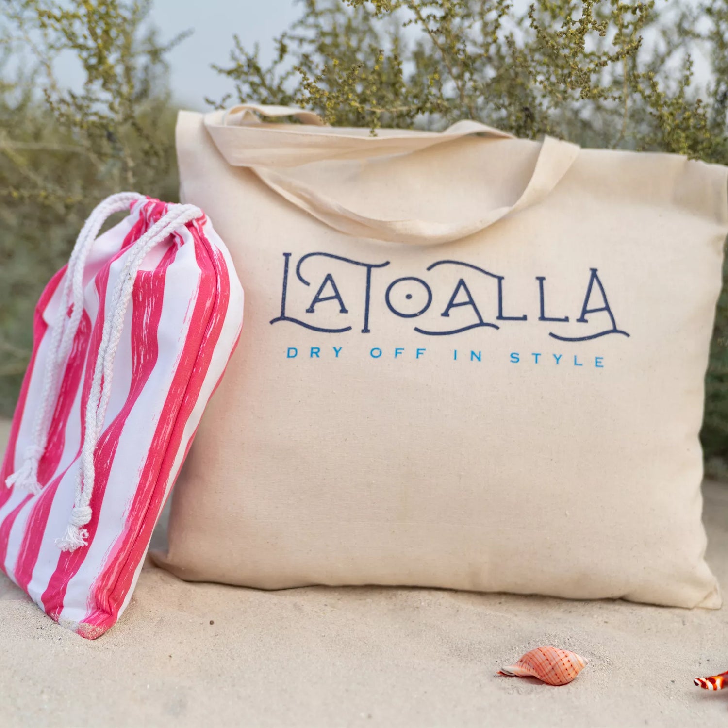a Quick Dry, Sand Free, Light Weight, Compact and Ecofriendly Microfiber Beach Towel pouch leaning on a La Toalla tote bag