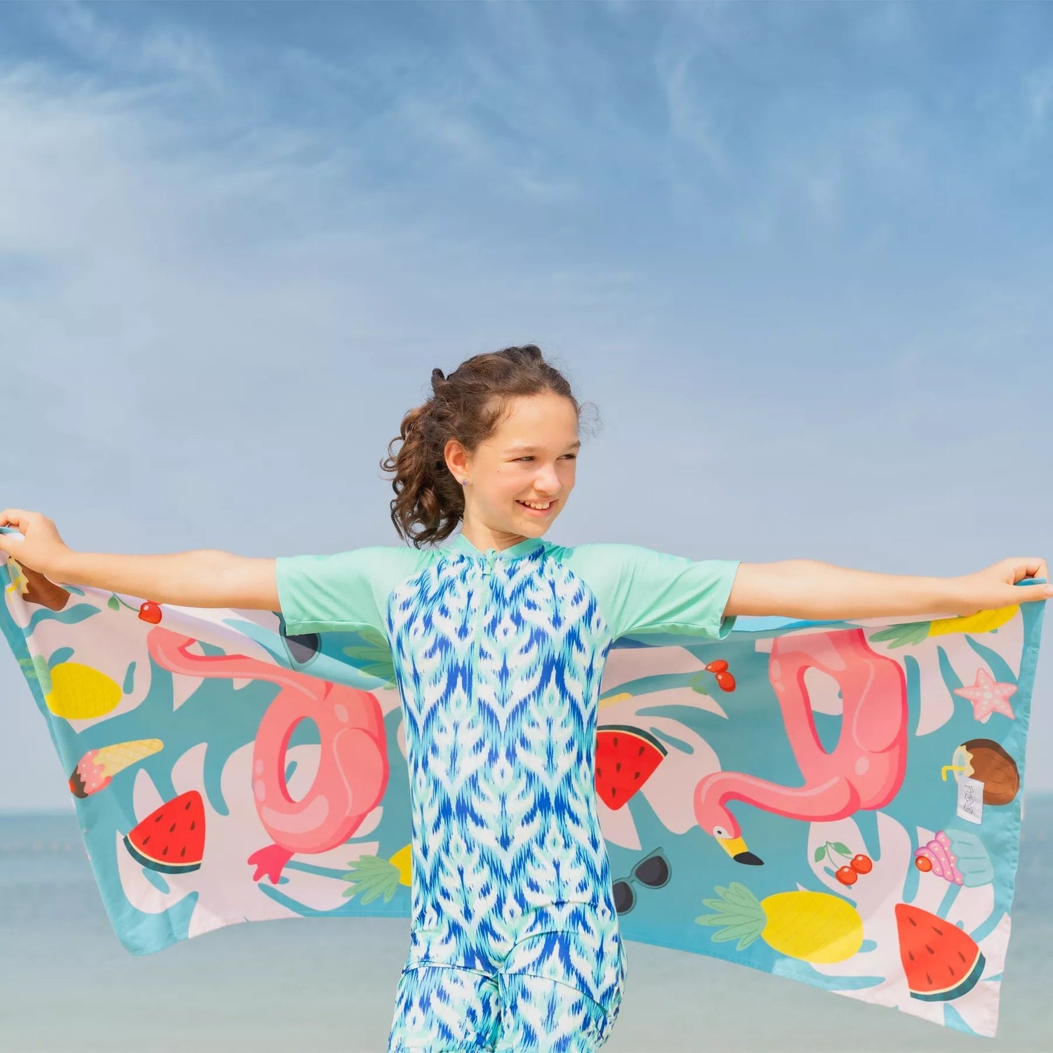 A girl holding a kids Quick Dry, Sand Free, Light Weight, Compact and Ecofriendly Microfiber Beach Towel from La Toalla